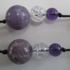 Zoom auf die Amethystkugeln einer Edelsteinkette aus Amethyst, Bergkristall und Rosenquarz.