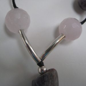 Zoom auf zwei Rosenquarzkugeln und silberne Zwischenteile einer Edelsteinkette aus Amethyst, Bergkristall und Rosenquarz.