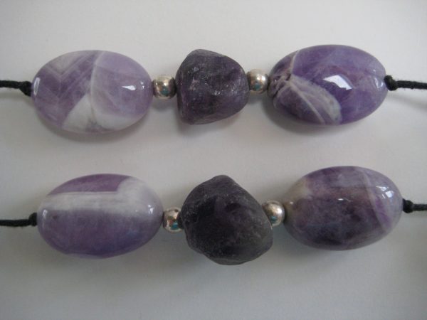 Zoom auf einzelne Steine einer Edelsteinkette aus Amethyst, Bergkristall und Rosenquarz in Lila- und Rosétönen.