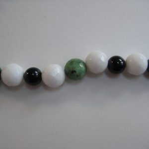 Fokus auf die einzelnen Steine einer Edelsteinkette aus Jade, Turmalin und Rubin-Zoisit.