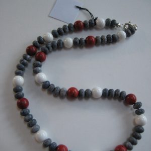 Aufgelegte Edelsteinkette aus Koralle und Jade mit roten, blauen und weißen Steinen.